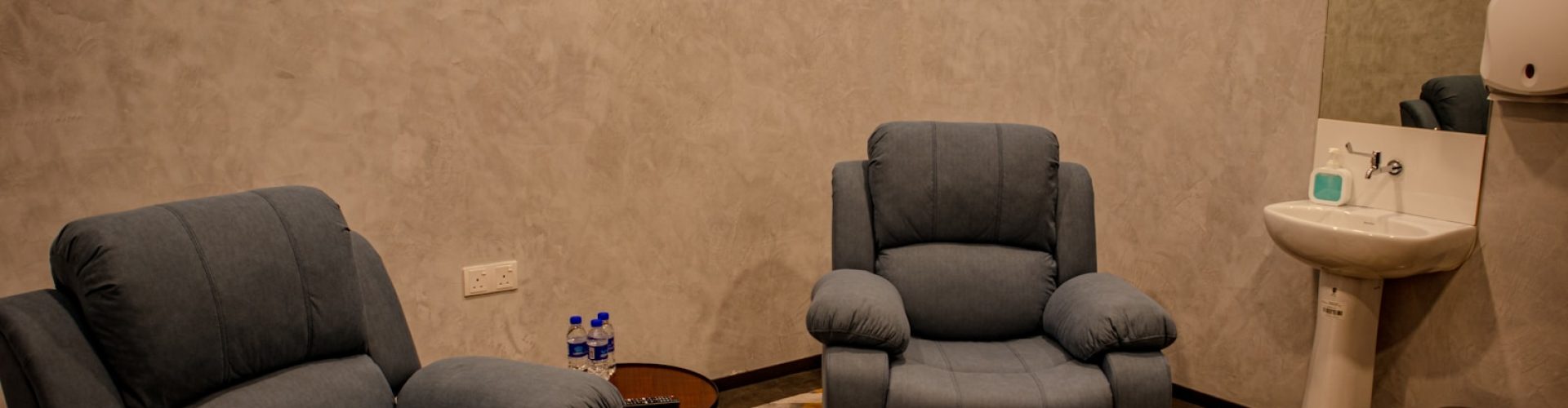 a living room with two recliners and a sink